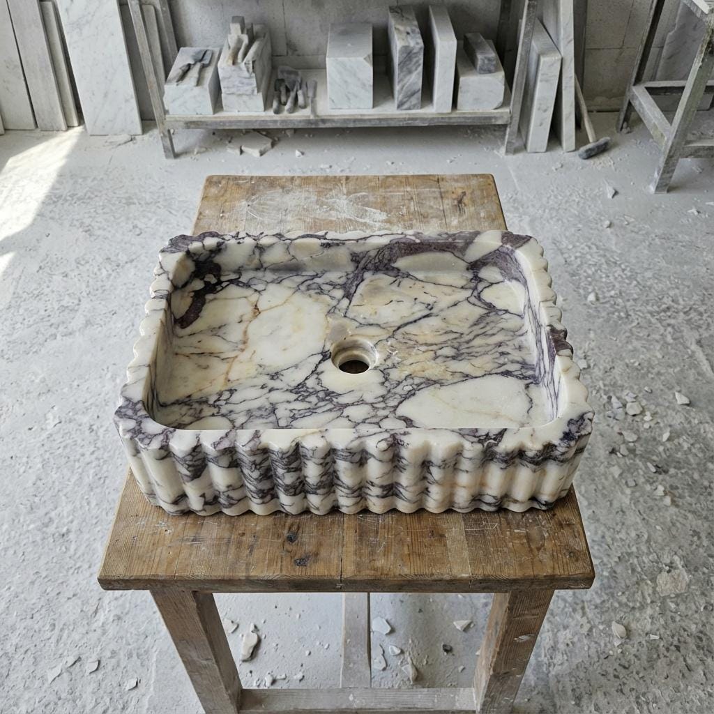 Hand-carved Calacatta Viola marble vessel sink with fluted sides in our workshop