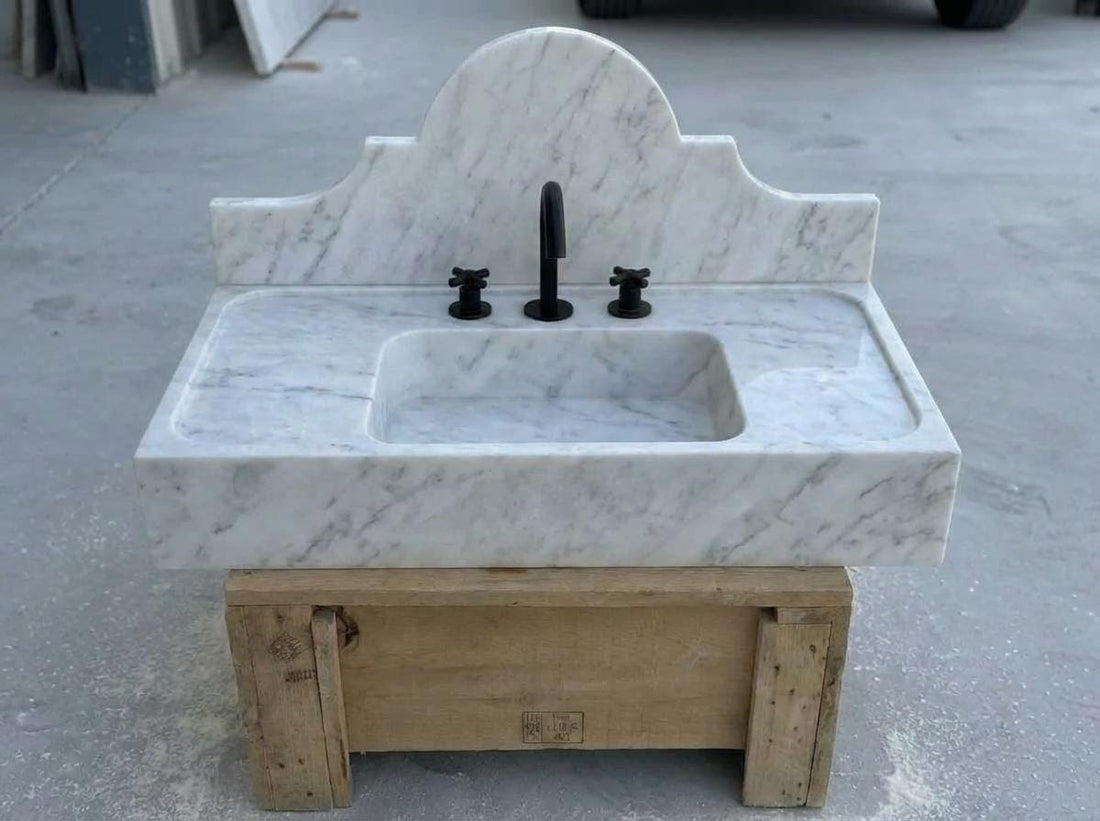 Handcarved Carrara marble rectangular vessel sink on a bathroom vanity