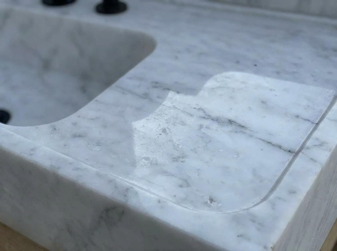 Honed Carrara marble sink surface showing natural stone texture