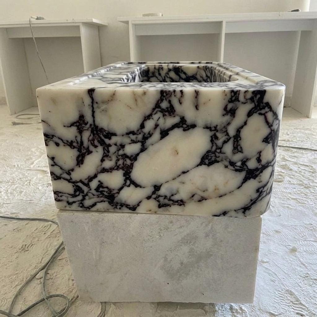 Calacatta Viola square vessel sink on a low stone base