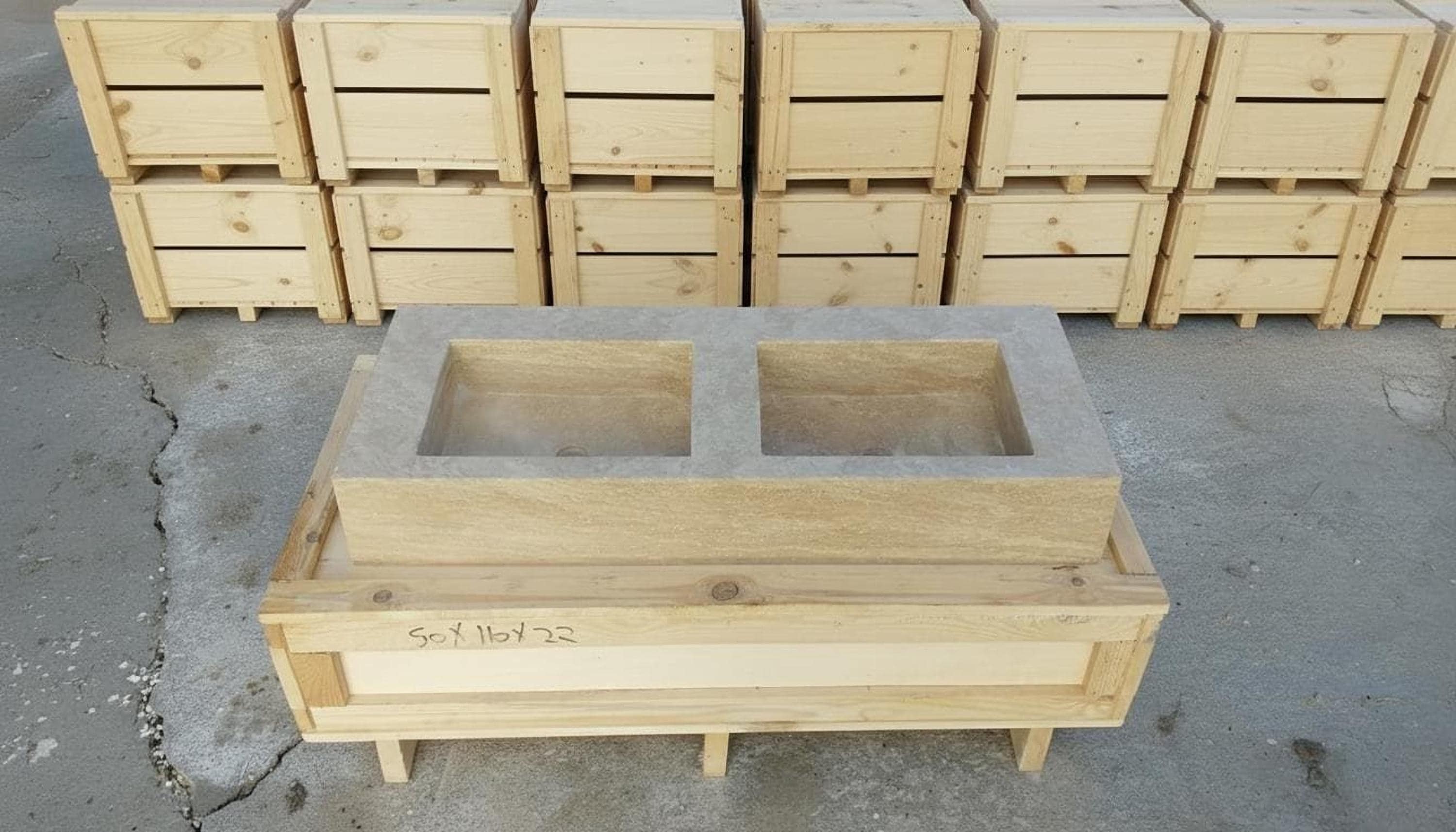 a wooden structure with two rectangular basins, surrounded by several wooden crates and boxes stacked on top of each other.